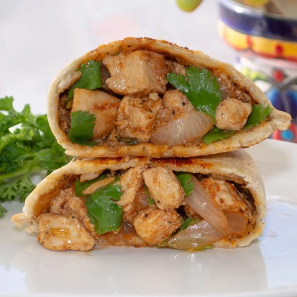 Two halves of a Big E Cafe chicken empanada, filled with chicken, onions, and cilantro.